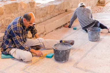 Two archaeologists meticulously restore the ancient synagogue of Magdala