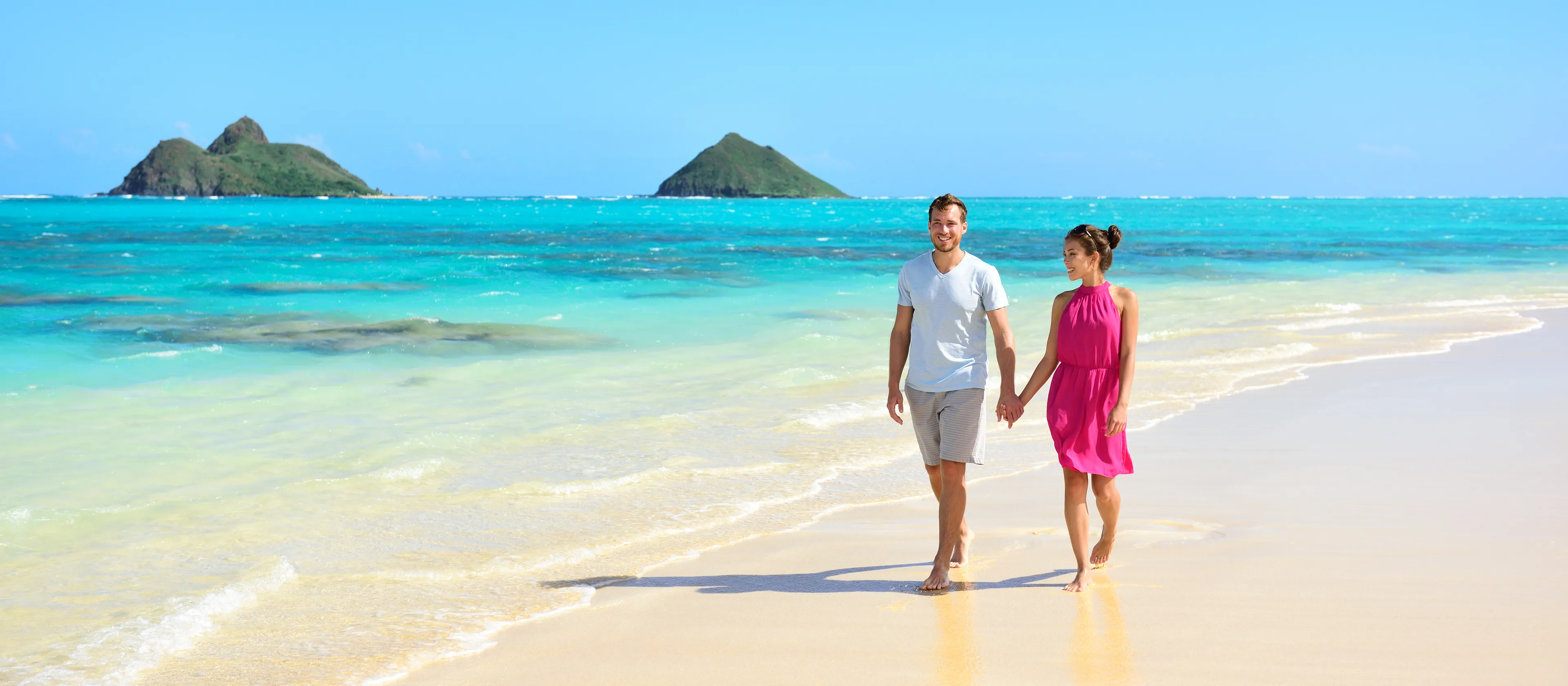 A smiling couple walking along the beach