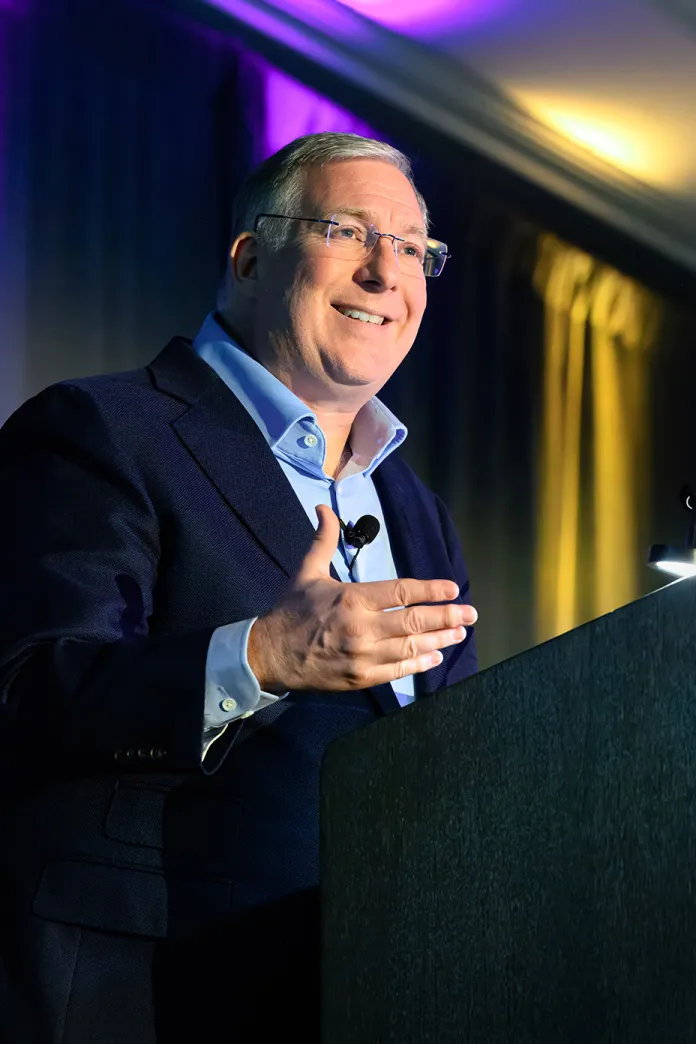 Joel C Rosenberg standing at podium, smiling