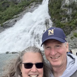 A smiling couple with a waterful in the background