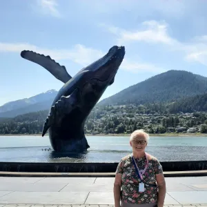 Smiling woman with a large statue of a whale in the background