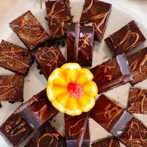 Chocolate squares on a plate with an orange sliced to look like a flower